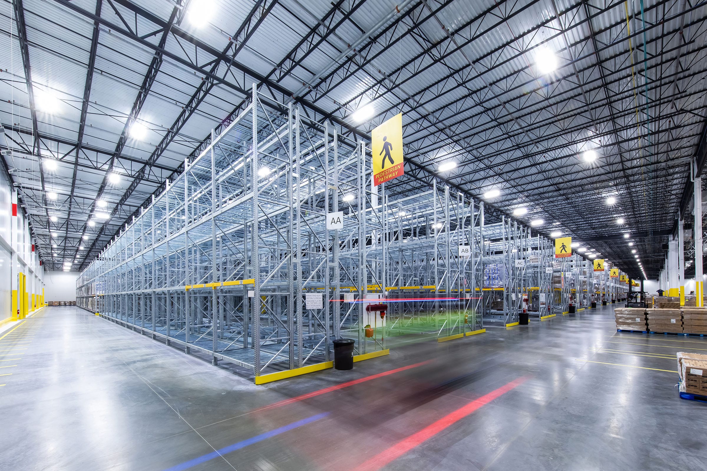 Large modern warehouse interior with tall metal shelving racks