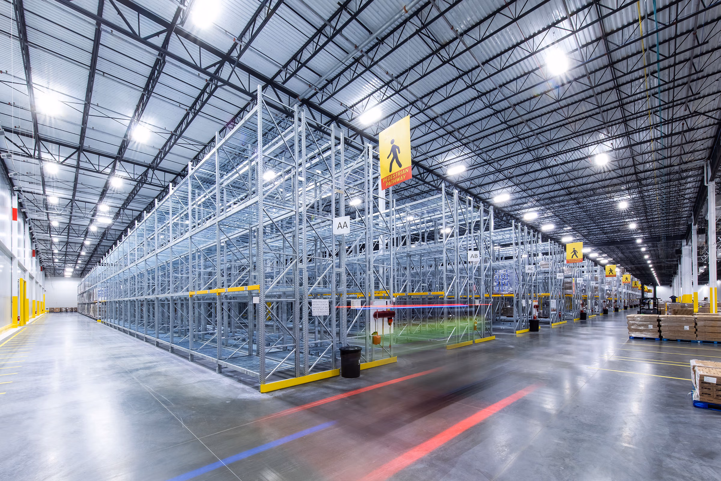Large modern warehouse interior with tall metal shelving racks